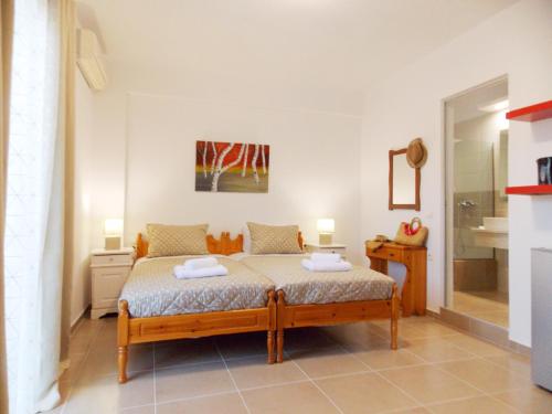 a bedroom with a bed with two towels on it at ERA Studios 1 in Skiathos