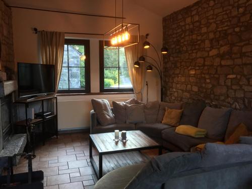 a living room with a couch and a table at La parenthèse in Chimay