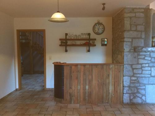 a bar in a room with a clock on the wall at La parenthèse in Chimay