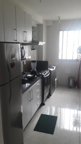a kitchen with a stainless steel refrigerator and a stove at Apart Varanda do Poxim in Aracaju