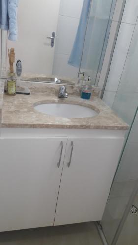 een badkamerbar met een witte wastafel en een spiegel bij APTº NOVO NO SANTA LÚCIA in Aracaju