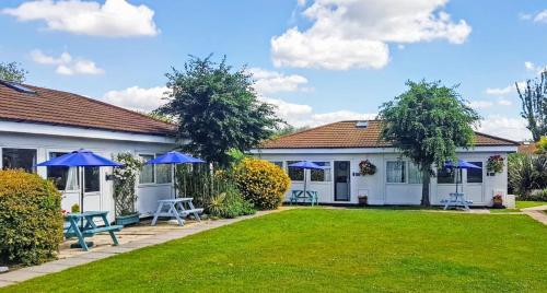 a house with blue umbrellas in a yard at Dawlish Warren Holidays in Dawlish