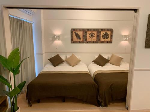 Duas camas num quarto com um espelho em Allstay CHIBANA em Okinawa