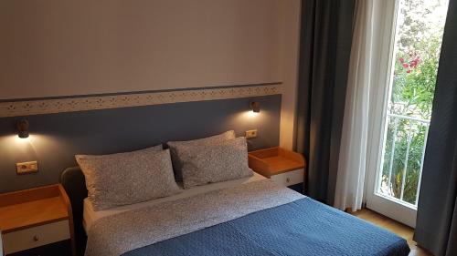 1 dormitorio con 1 cama con 2 almohadas y ventana en Marion apartment en Portorož
