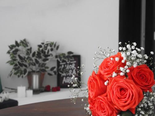 a bouquet of red roses sitting on a table at Residencial Vila do Sol, Apartamentos com pé na areia in Bombinhas