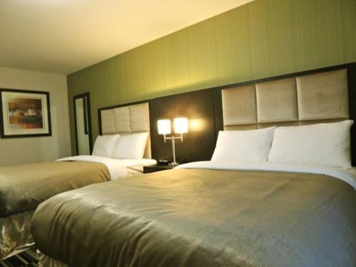 a hotel room with two beds and two lamps at Western Star Inn & Suites Esterhazy in Esterhazy