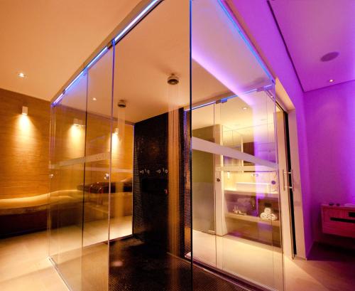 a room with a glass wall and purple lights at Lush Motel Ipiranga in Sao Paulo