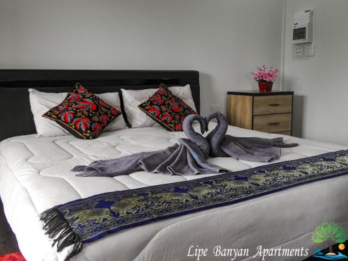 a bed with two blankets and pillows on it at Lipe Banyan Apartments in Ko Lipe