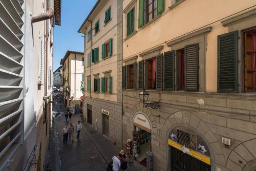 eine Gruppe von Menschen, die eine Straße entlang gehen, neben Gebäuden in der Unterkunft Sant'Antonino Apartments in Florenz