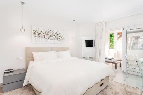 マルベーリャにあるby RIVA - Stylish 2 Bedroom Luxury Apt in Naranjos Puerto Banusの白いベッドルーム(白いベッド1台、窓付)