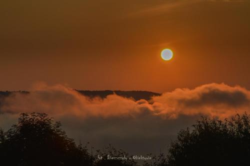 a sunset with the sun rising above the clouds at Apartament Zacisze in Uherce Mineralne