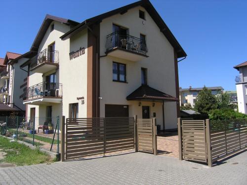 una casa con una valla de madera delante de ella en Willa Wanta, en Władysławowo
