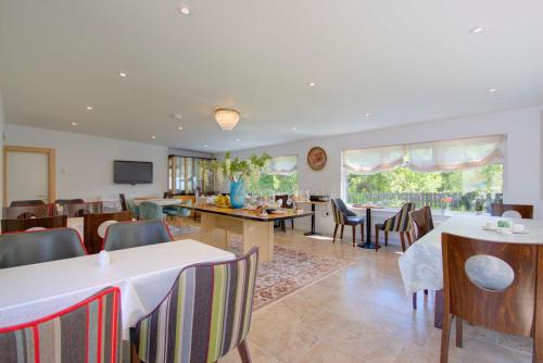 a dining room with tables and chairs and a kitchen at Loch Earn in Inverness