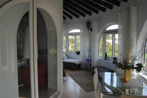 ein Wohnzimmer mit Bogenfenstern und einem Glastisch in der Unterkunft Villa Bozena in Denia