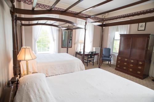 a bedroom with two beds and a desk in it at Middlebury Inn in Middlebury