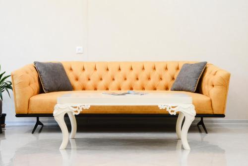 an orange couch with a white coffee table at Bellis in Tbilisi City