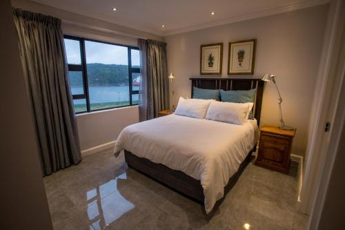 a bedroom with a bed and a large window at Stay at The Point - Penthouse Plush Perfection in Durban