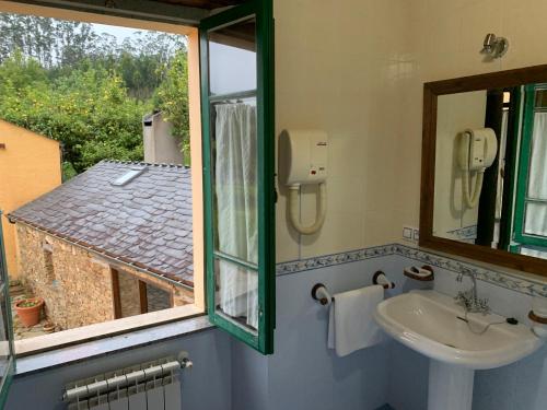 La salle de bains est pourvue d'un lavabo et d'une fenêtre. dans l'établissement Casa da Roxa, à Foz