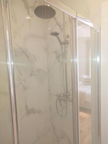 a shower with a glass door in a bathroom at Oporto Glamour Suite House in Vila Nova de Gaia