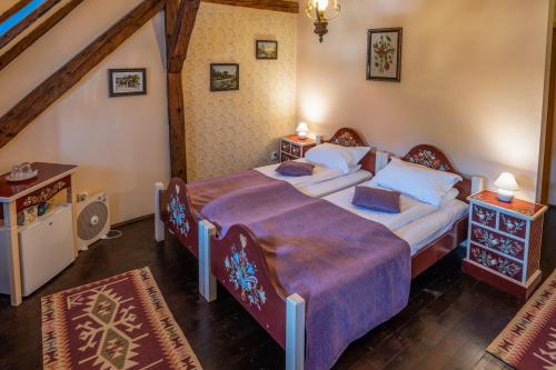 a bedroom with two beds and a staircase at Casa Saseasca in Sighişoara