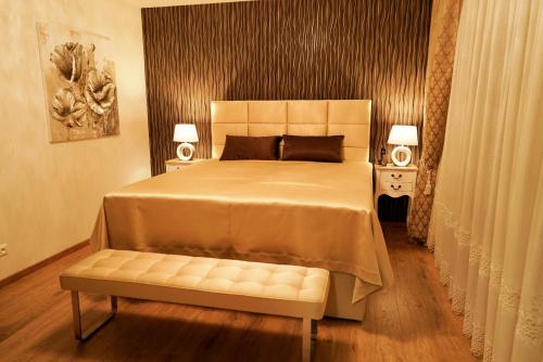 a bedroom with a large bed and a bench at Luxury Villa in Moravany nad Váhom