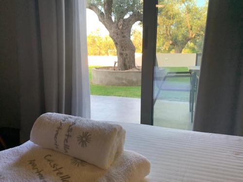 a bed with two towels sitting on top of it at Castella Apartments in Vourvourou