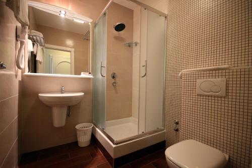 a bathroom with a shower and a toilet and a sink at Hotel Bella Vista in Budva