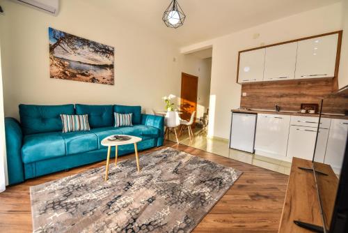 ウルツィニにあるDragovoja Lux Apartments & Roomsの青いソファとキッチンのあるリビングルーム