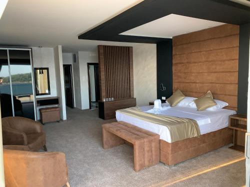 a bedroom with a bed and a couch and a chair at Apart Lux Beciragic in Dobra Voda