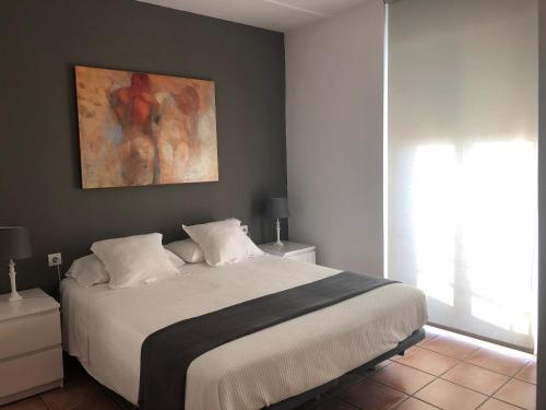a bedroom with a bed and a painting on the wall at Colón Market Downtown in Valencia