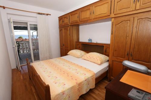 a bedroom with a bed and a desk and a window at Apartman Luna in Dugi Rat
