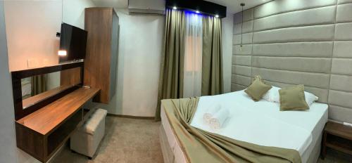 a bedroom with a white bed and a television at Apart Lux Beciragic in Dobra Voda