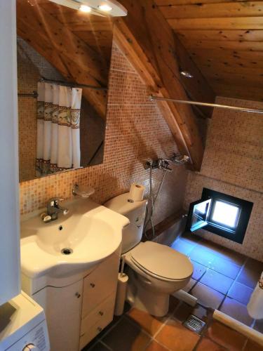 a bathroom with a white toilet and a sink at El Mar House Parga in Parga
