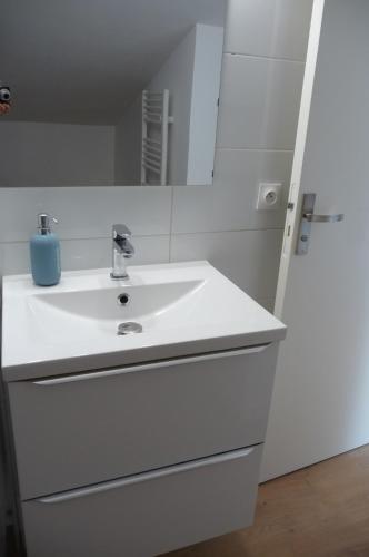 a white bathroom with a sink and a mirror at Le balcon de la Conche in Royan