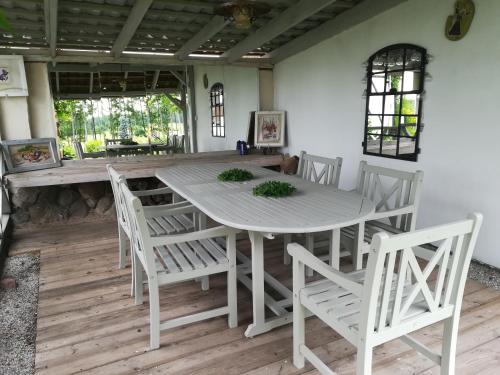 a dining room with a white table and chairs at Wiejska Chata in Szwalk