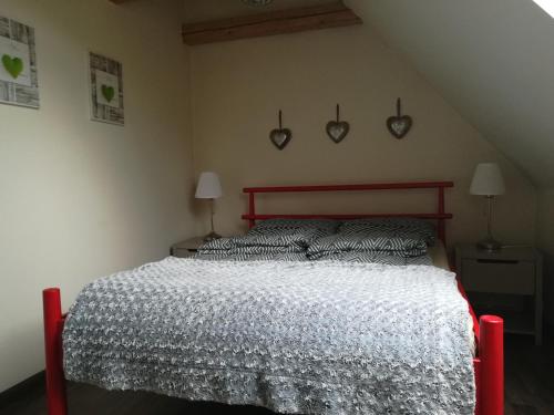 a bedroom with a bed with a white comforter and two lamps at Wiejska Chata in Szwalk