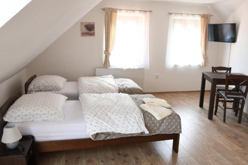 a bedroom with a bed and a desk and windows at Penzion-apartmán Souček in Jindrichuv Hradec