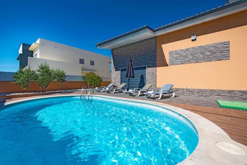a large swimming pool in front of a building at AZEITÃO DAMAS VILLA in Azeitao