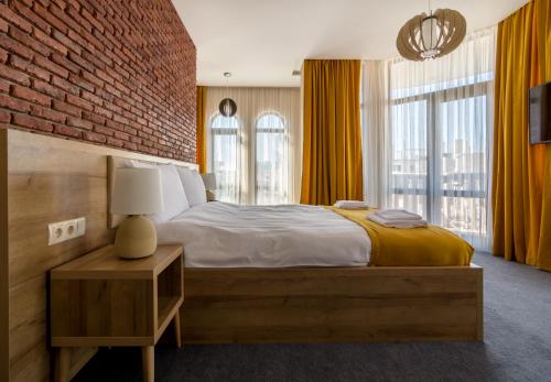 a bedroom with a large bed and a brick wall at Hotel London in Batumi