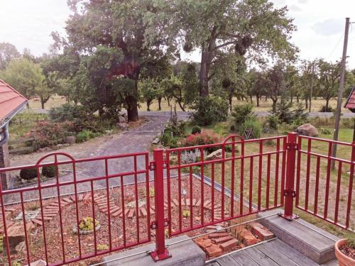a red metal gate on a wooden walkway at Ziegeleihof inmitten von Wiesen und Wäldern in Degenershausen