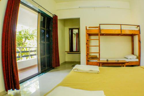 a bedroom with two bunk beds and a window at Rainwood Residency in Lonavala