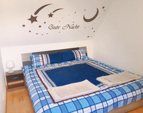 a bedroom with a bed with a sign on the wall at Schöne Zeit 2 rooms apartment with kitchen in Friedrichshafen
