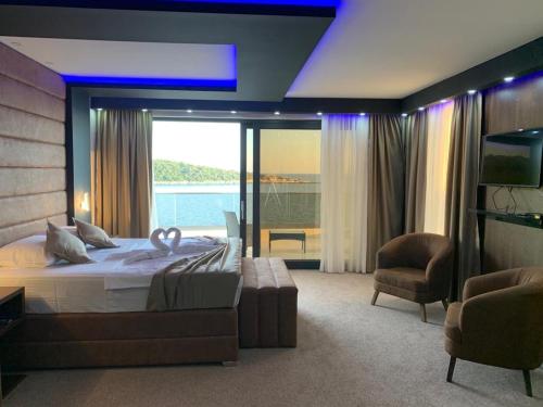 a bedroom with a large bed and a large window at Apart Lux Beciragic in Dobra Voda