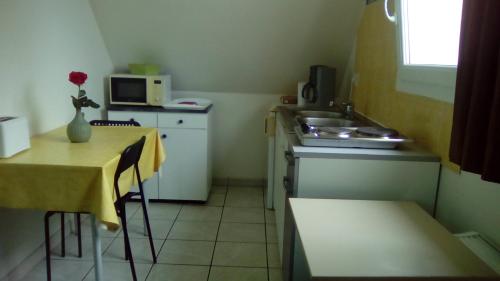 studio évasion في Éterville: مطبخ صغير مع طاولة ومطبخ صغير مع حوض