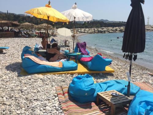 a group of people laying on a beach at Agali 2 maizonette front of the sea in Akrogiali