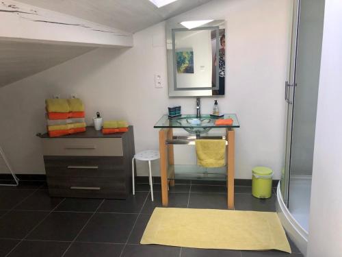La salle de bains est pourvue d'un lavabo et d'une coiffeuse avec un miroir. dans l'établissement Le Loft des Musiciens, à Mulhouse