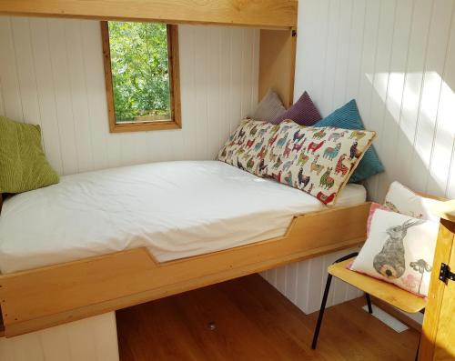 a small bed in a small room with a window at The Llama Hut in Kirk Leavington