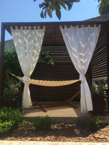 a hammock with curtains on a wooden deck at Dimora La Grazia in Castelvetrano Selinunte