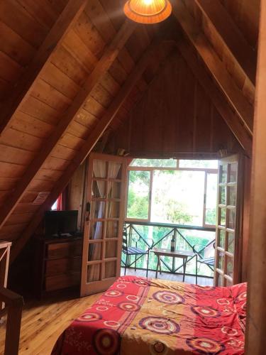 a bedroom with a bed and a large window at Hotel Chalets Los Volcanes in Alajuela City