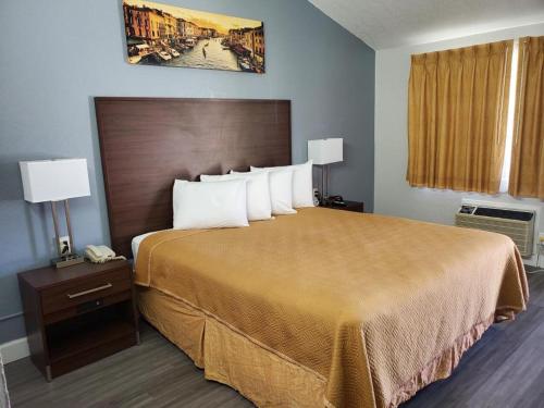 Habitación de hotel con cama grande con almohadas blancas en Bestway Inn, en Paso Robles